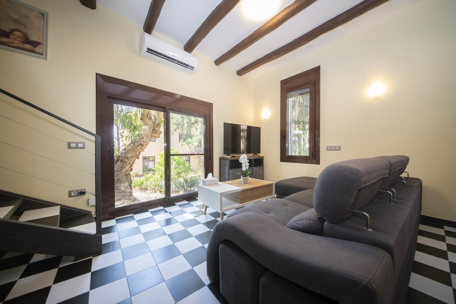 El salón, con TV y salida al jardín