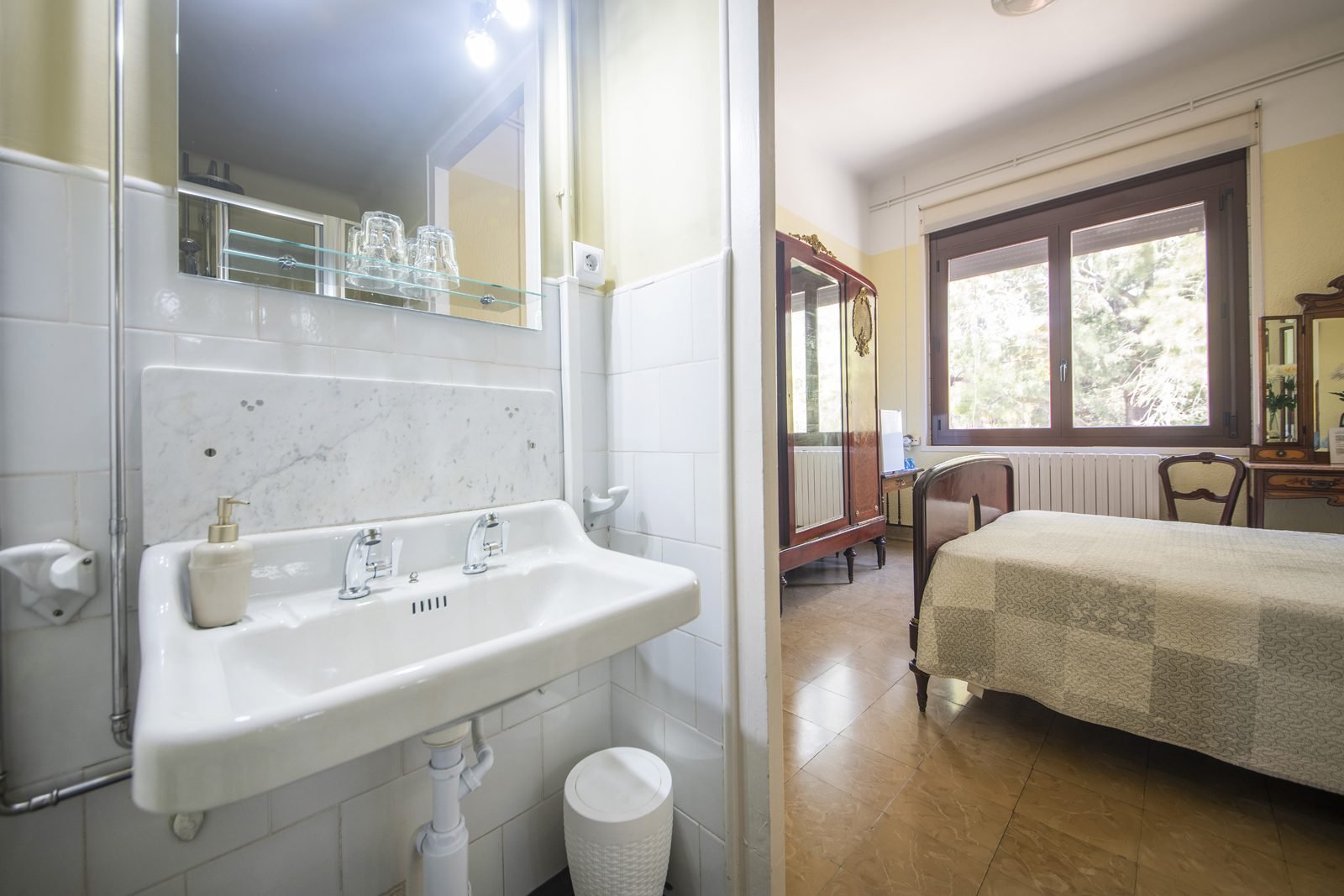 El baño privado, con la habitación al fondo