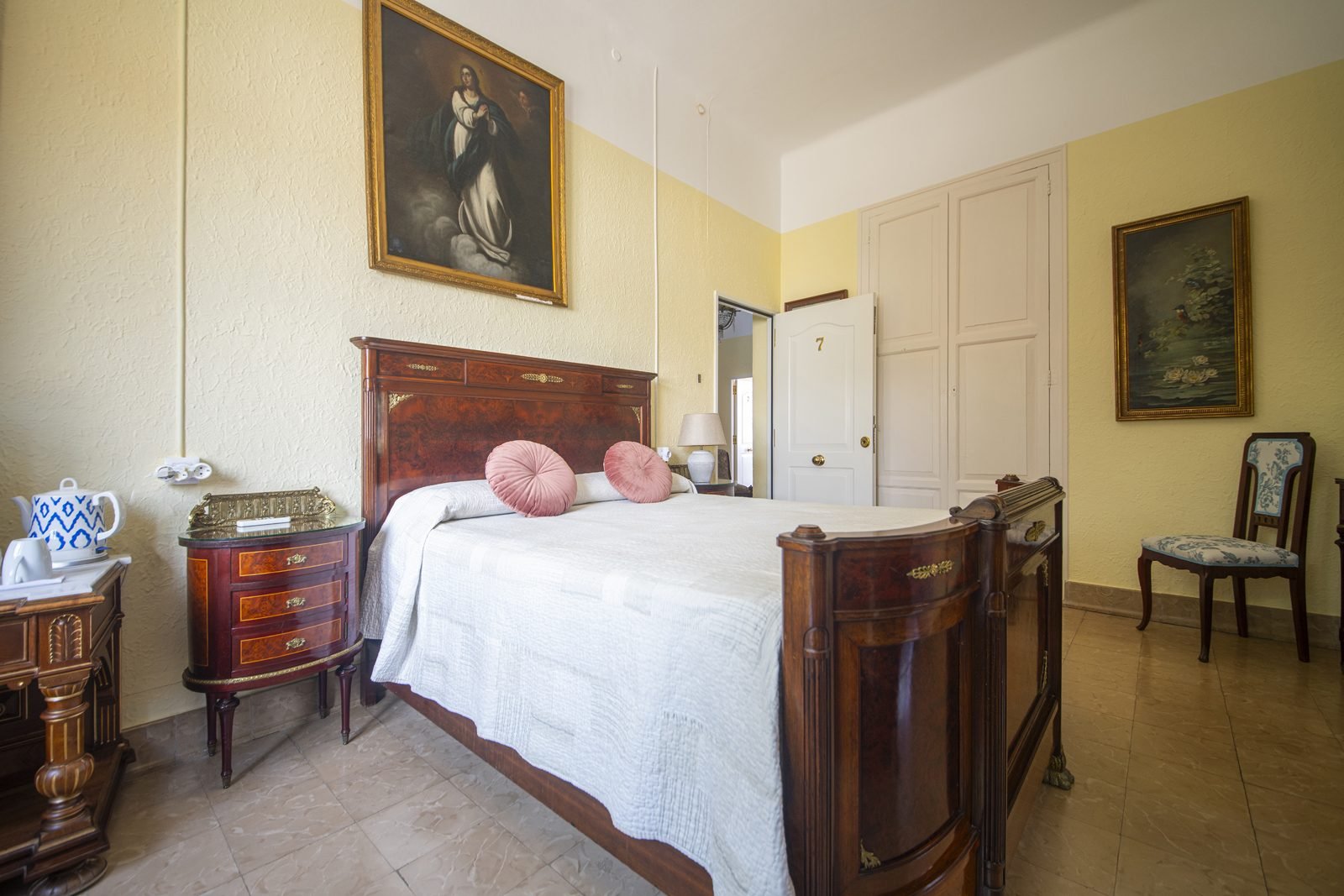 La cama de matrimonio, bajo los cuadros